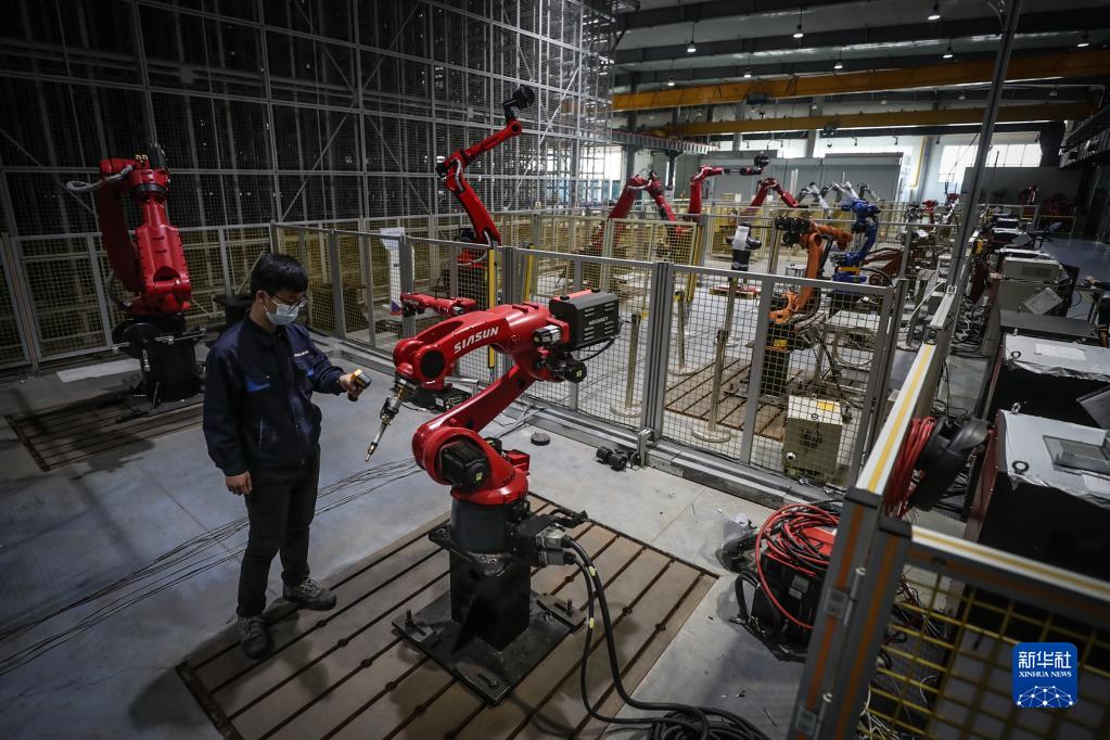 2022年4月28日，新松機(jī)器人自動(dòng)化股份有限公司的工作人員在生產(chǎn)車(chē)間內(nèi)調(diào)試機(jī)器人。新華社記者 潘昱龍 攝
