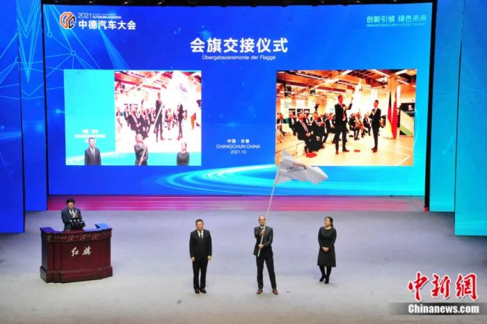 2021年10月19日，2021中德汽車大會在吉林長春舉行。中外汽車領(lǐng)域的專家學(xué)者、知名汽車廠商及汽車零部件企業(yè)代表和政府官員，圍繞“創(chuàng)新引領(lǐng) 綠色未來”主題展開探討。圖為中德汽車大會會旗交接儀式。高龍安 攝