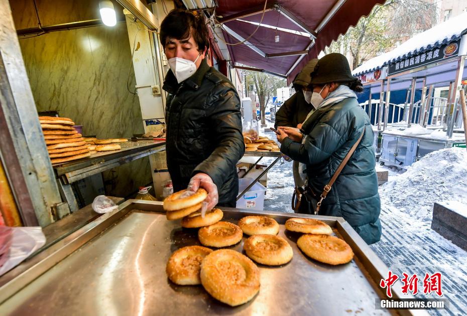 烏魯木齊市文化路，已開門營業(yè)的馕店吸引過往市民前來購買。 劉新 攝