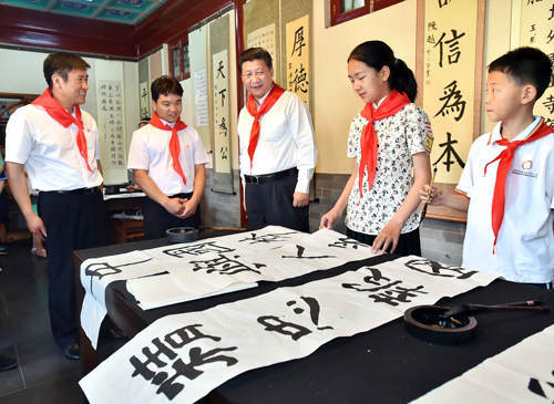 2014年5月30日上午，中共中央總書(shū)記、國(guó)家主席、中央軍委主席習(xí)近平來(lái)到北京市海淀區(qū)民族小學(xué)，參加慶?！傲弧眹?guó)際兒童節(jié)活動(dòng)。這是習(xí)近平觀看學(xué)生書(shū)寫的毛筆字。新華社記者 李濤 攝