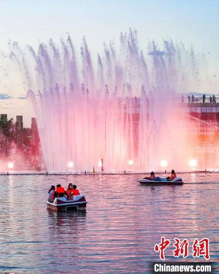 游客在北屯市新區(qū)玉帶河乘船游玩。(資料圖) 李正虎 攝