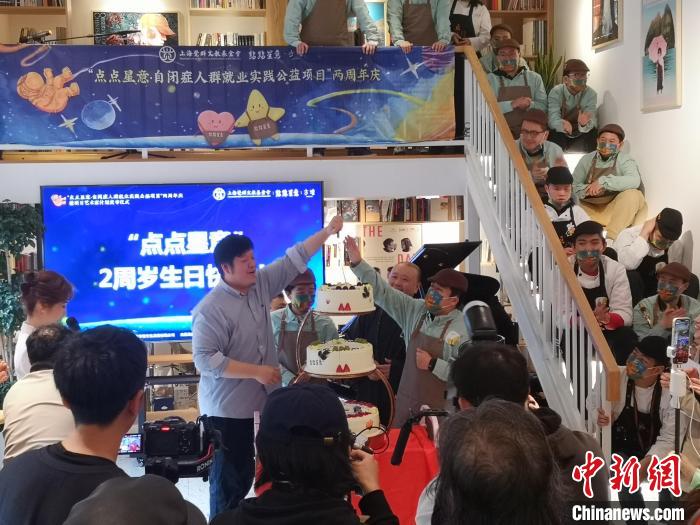 黃悅與自閉癥咖啡師共同切蛋糕，慶祝“點點星意”自閉癥人群就業(yè)實踐公益項目發(fā)起兩周年。　范宇斌 攝